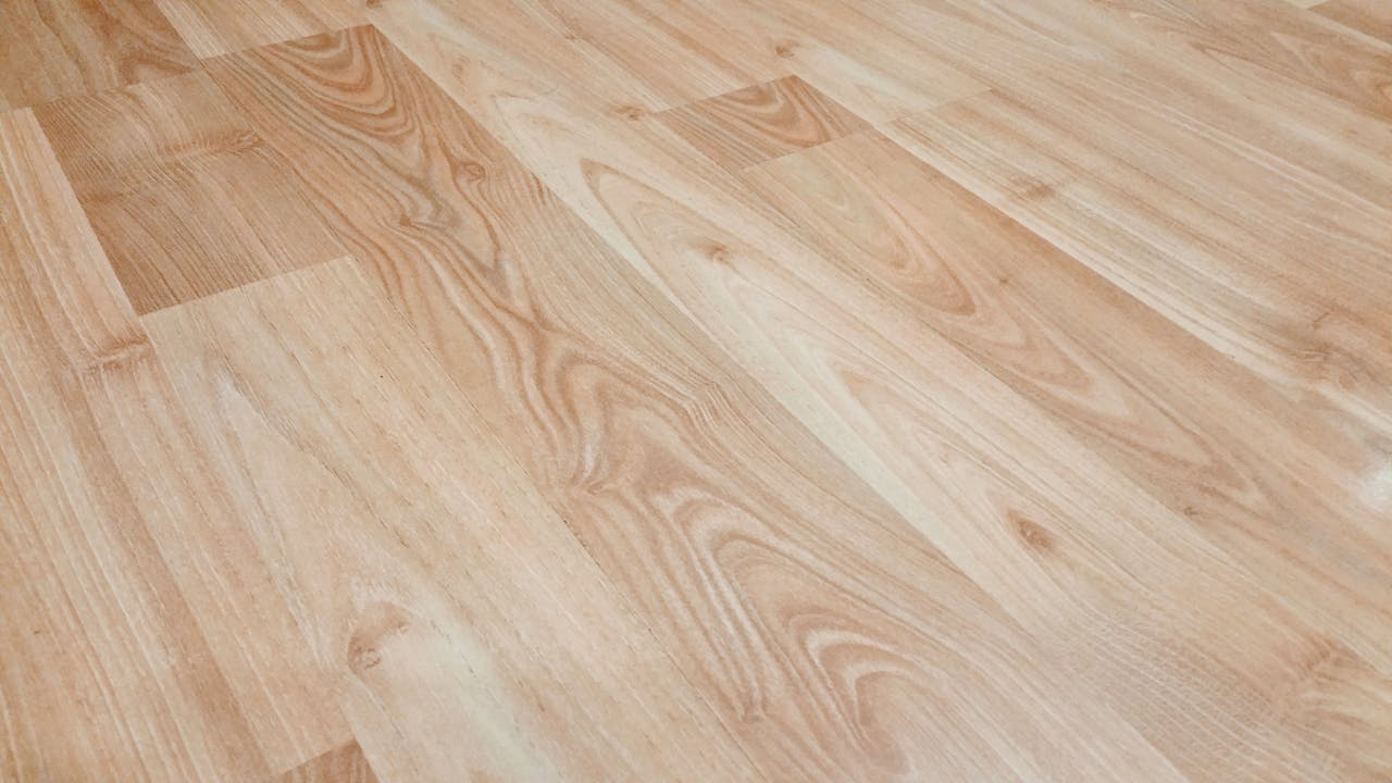 Smooth light brown wooden flooring with natural texture and patterns.