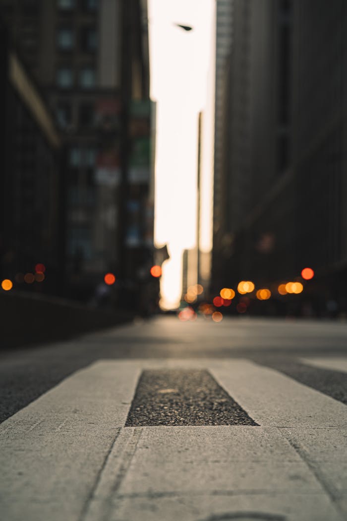 Dramatic low angle view of a city street with blurred buildings and sunset lighting.
